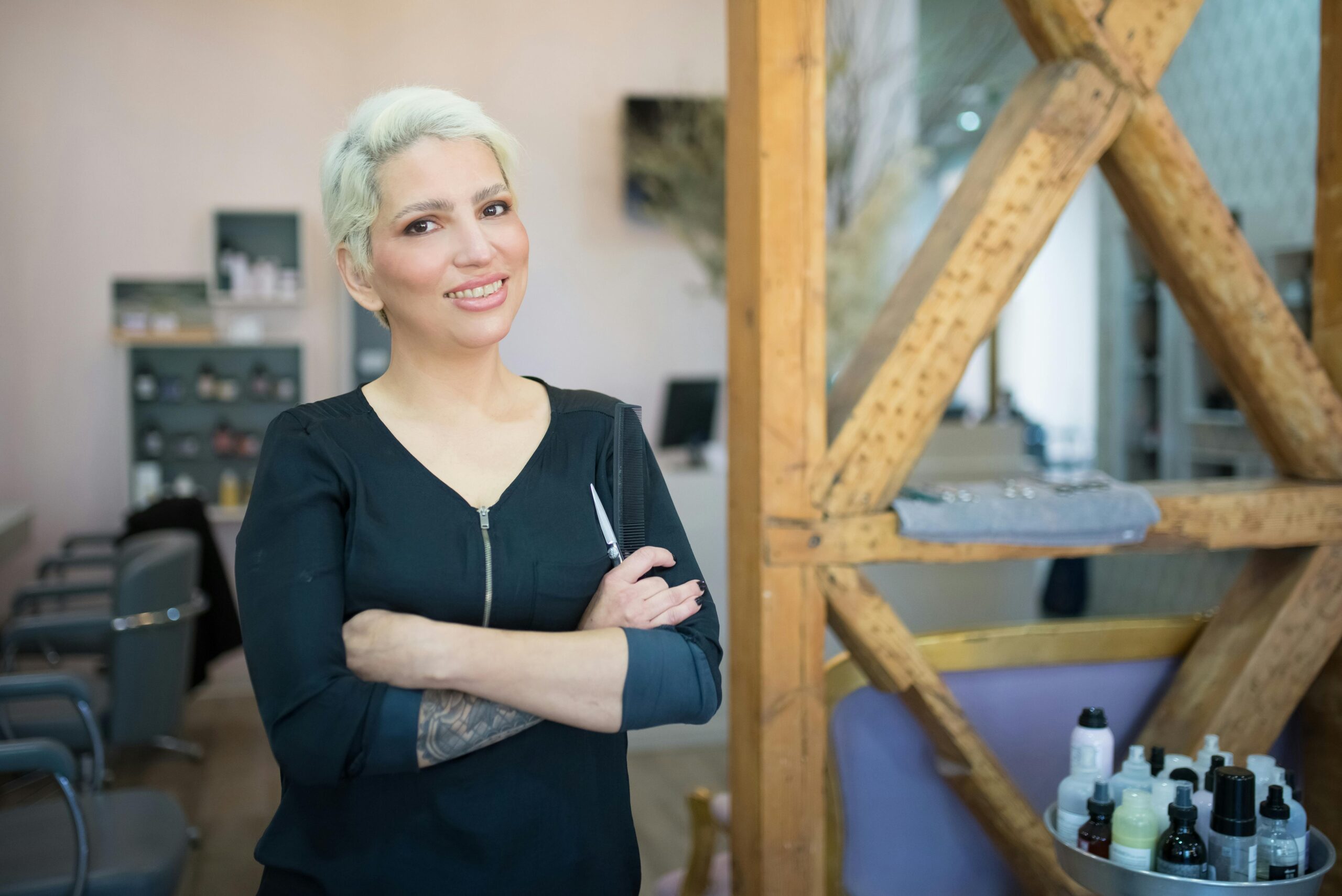 A confident female hair stylist smiling in a contemporary salon in Portugal.
